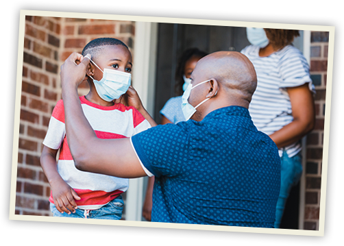 father helping son put on facemask