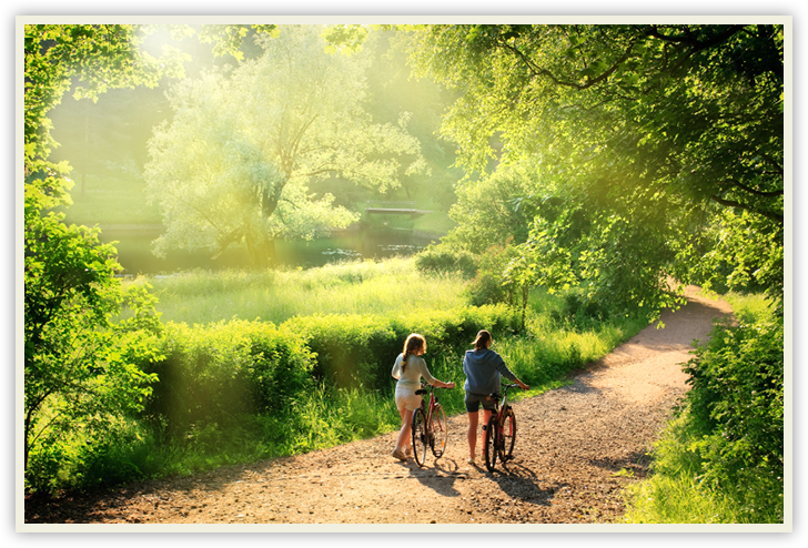 couple walking bikes down path